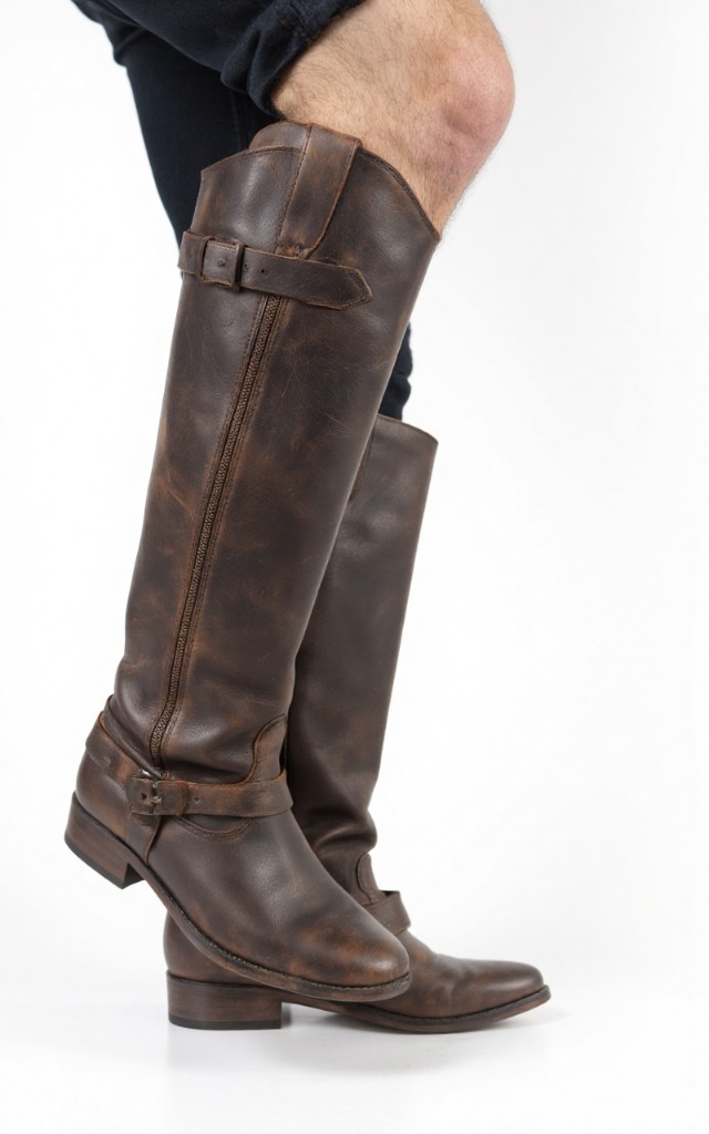 A male model wearing Riding boots, against a white background, with a close   up of the feet